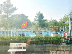 a bench in front of a park with a flag at Saigon Getaway Apartment Thu Duc in Ho Chi Minh City