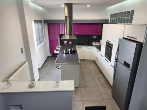 a kitchen with white appliances and purple walls at DENNIS PATRASSO - Modern apartment in Patras in Patra +16 photos