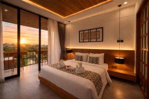 a bedroom with a large bed and a balcony at Omkara Dharman Ubud Villa By Omkara Experience in Ubud