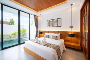 a bedroom with a bed with two stuffed animals on it at Omkara Dharman Ubud Villa By Omkara Experience in Ubud