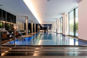 a swimming pool in a building with windows at Royal Savoy Hotel & Spa in Lausanne