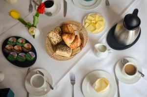 a table with plates of bread and cups of coffee at Hotel Alina in Wiesbaden