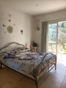 a bedroom with a bed and a window and a door at Les murmures du jardin in Pégomas