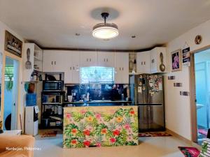 a kitchen with a refrigerator and a counter top at Camigs Vacation House in Mambajao