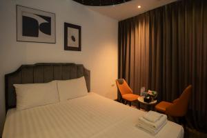 a hotel room with a bed and two chairs at Boutique Hotel in Hanoi