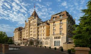 a large building with a tower on top of it at Royal Savoy Hotel & Spa in Lausanne