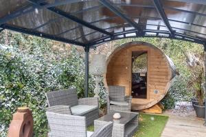 a wooden pergola with chairs and a dog house at Ospa in Hamois