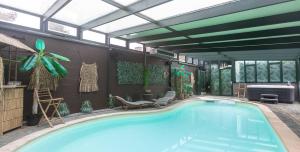 a large swimming pool in a building with a pool at Ospa in Hamois