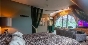 a bedroom with a bed and a couch and a tv at Ospa in Hamois +52 photos