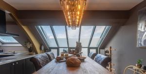 a dining room with a table and a chandelier at Ospa in Hamois