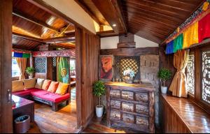 a living room with a red couch and colorful curtains at 丽江无尔雪山下泳池花园民宿 in Lijiang