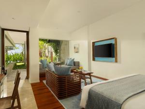 a bedroom with a bed and a living room at Maya Sanur Resort & Spa in Sanur