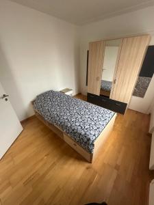 a small bedroom with a bed and a mirror at Appartement proche aéroport in Blotzheim