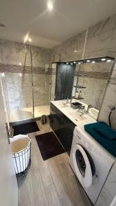 a washing machine in a bathroom with a tub at Appartement proche aéroport in Blotzheim +13 photos