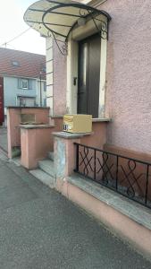 a box is sitting on the porch of a building at Appartement proche aéroport in Blotzheim
