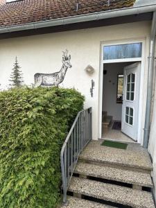 a statue of a deer on the side of a house at Pension Katharina im Solling in Holzminden