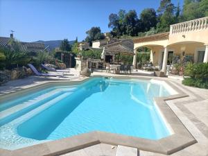 a swimming pool in a yard with a house at Les murmures du jardin in Pégomas