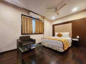 a hotel room with a bed and a chair and a table at Hotel Lee International in Kolkata +37 photos