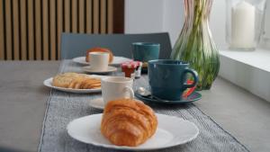 a table with two plates of croissants and coffee cups at A Casa Mia 2.0 in Saronno