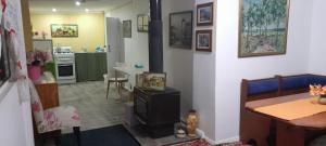 a living room with a table and a kitchen at Blue Flower Cottage in Lightning Ridge