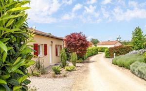 a house on a dirt road with bushes and trees at French country home II in Les Forges