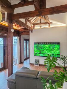 a living room with a large flat screen tv on the wall at 안동 108한옥 in Andong