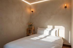 a bedroom with a bed with white sheets and pillows at 안동 108한옥 in Andong +35 photos