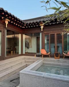a patio with a pool and chairs and a house at 안동 108한옥 in Andong