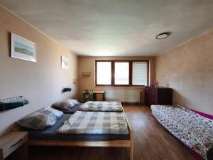 a bedroom with two beds and a window at Apartmány ŠTĚSTÍ in Bechlín