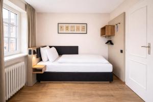 a small bedroom with a bed and a window at Stadthotel Jülich in Jülich