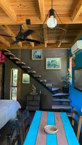 a room with a blue table and a bed and stairs at Casa Quinta Ecológica "Coruya Wild" in Santa Ana