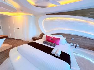 a bedroom with a large white bed with pink pillows at Condohotel The Carmen Deluxe Oceanview King Suite in Playa del Carmen