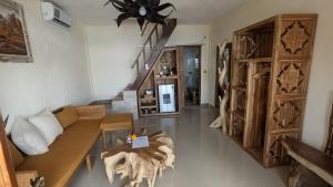 a living room with a couch and a staircase at Sandy Beach Villas in Toyapakeh