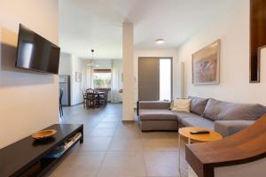 a living room with a couch and a tv at Baveno Beach - Charming Flat With Garden in Baveno