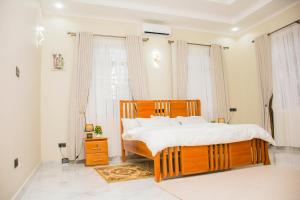 a bedroom with a wooden bed and a large window at KiliView Homestay in Moshi