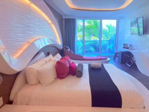 a bedroom with a large bed with colorful pillows at Condohotel The Carmen Deluxe Oceanview King Suite in Playa del Carmen