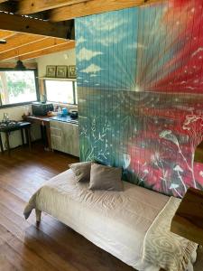 a bedroom with a bed in a room with a wall at Casa Quinta Ecológica "Coruya Wild" in Santa Ana