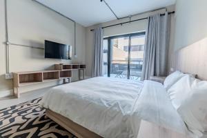 a bedroom with a large bed and a television at inn here in Johannesburg