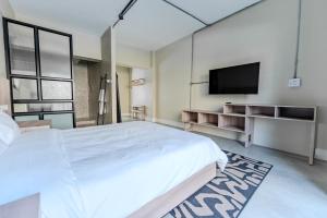a bedroom with a large bed and a flat screen tv at inn here in Johannesburg +4 photos