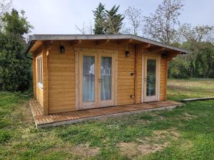 a small cabin with a deck in a field at Chambre d'hôte le petit chalet in Sénas