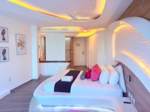 a bedroom with a bed with colorful pillows at Condohotel The Carmen Deluxe Oceanview King Suite in Playa del Carmen