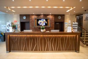 a lobby with a reception counter with flowers on the wall at Wellness Hotel Gyula in Gyula +72 photos