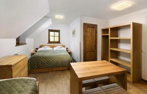 a small bedroom with a bed and a table at Majláthova Chata Popradské Pleso in Vysoké Tatry
