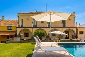 a villa with a swimming pool and an umbrella at Villa Solenia in Giarre