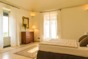a bedroom with a bed and a dresser and a mirror at Villa Solenia in Giarre