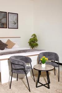 two chairs and a table in a room at رخاء للغرف الفندقية in Firq