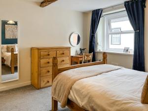 a bedroom with a bed and a dresser and a window at North Lakes Town House in Penrith +5 photos