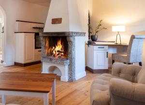 a living room with a fireplace and a couch at ARCOTEL Castellani Salzburg in Salzburg