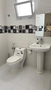 a white bathroom with a toilet and a sink at رخاء للغرف الفندقية in Firq