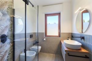 a bathroom with a sink and a toilet and a mirror at Baveno Beach - Charming Flat With Garden in Baveno +40 photos